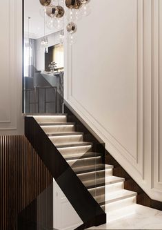 an elegant staircase with chandelier and glass balls hanging from the ceiling above it