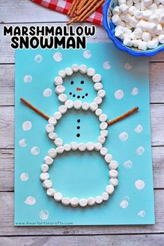 marshmallow snowman craft for kids to make on the table with pretzels