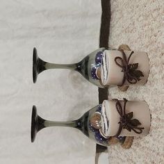 two vases sitting next to each other on a carpeted floor in front of a white curtain