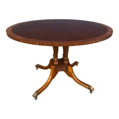 an oval wooden table with four legs and two leaves on each end, in the middle of