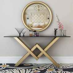 a table with a mirror, vase and candles on it in front of a wall