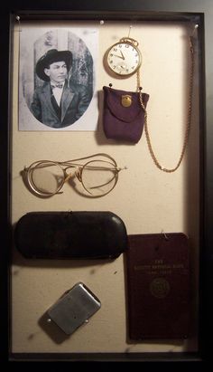 an assortment of items is displayed in a shadow box with a clock, passport, and sunglasses