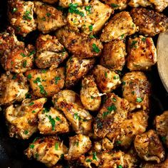 chicken with parsley in a skillet and a wooden spoon