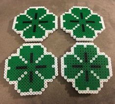 four green shamrock coasters sitting on top of a table