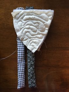 a piece of cloth with a tie on it sitting on top of a wooden table