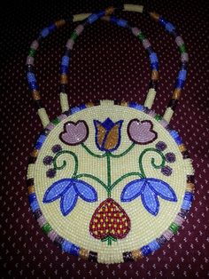 a beaded purse with flowers on it sitting on top of a red table cloth