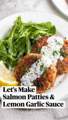 two white plates topped with crab cakes next to a green salad and lemon wedges