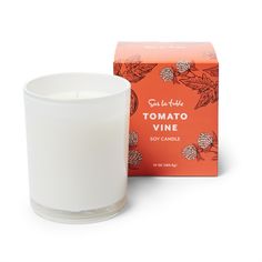 an orange box next to a white candle in front of a red box with the words tomato vine on it