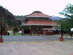 an old train station with mountains in the background