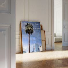 an empty room with a poster on the floor and a palm tree in the corner