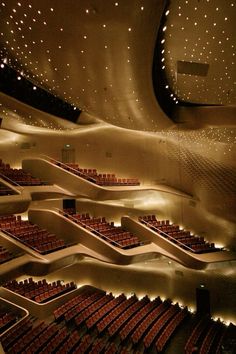 an empty auditorium with rows of seats and lights on the ceiling is lit up at night