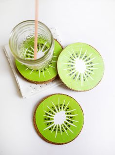 two slices of kiwi sitting on top of each other next to a glass with a straw