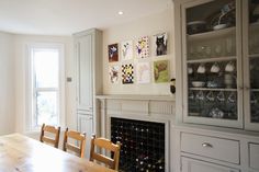 a dining room table with chairs and a china cabinet in front of the fire place