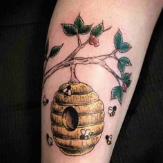 a tattoo with a beehive and leaves on it