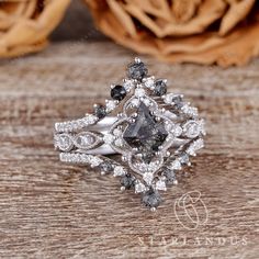 a fancy ring with black and white diamonds on it, sitting on a wooden surface