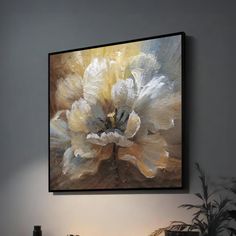 an abstract painting hangs on the wall above a table with a lamp and potted plant