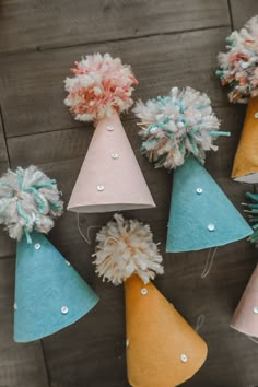 paper cones with pom poms on them are sitting on the floor next to each other