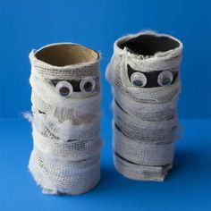 two pairs of shoes made out of toilet paper with googly eyes and yarn wrapped around them