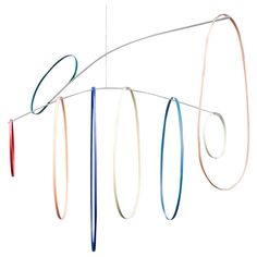 an artistic sculpture made out of different colored ribbons hanging from it's sides, with one string attached to the other