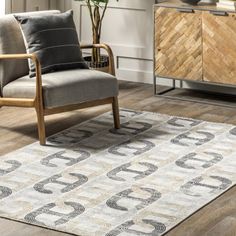 a living room area with a chair, rug and sideboard in the middle of it