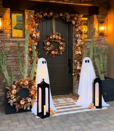 two ghost lanterns are on the front steps of a house decorated with cacti and succulents