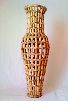 a vase made out of wicker sitting on top of a white table next to a wall