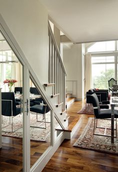 a dining room table with black chairs next to a stair case