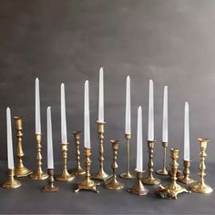 a bunch of candles that are sitting in the middle of a row on a table