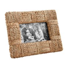 a woven photo frame with an image of two people holding a baby in the center