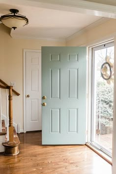 an empty room with a blue door and wooden floors