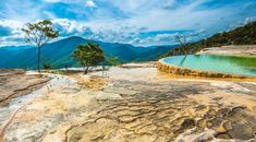 an outdoor hot springs with trees and mountains in the background