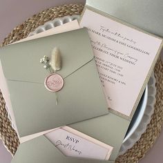 the wedding stationery is laid out on top of each other, including an envelope with a wax stamp