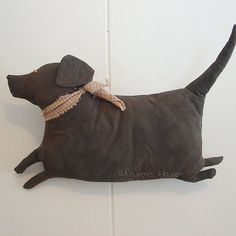 a gray stuffed dog laying on the floor with a ribbon around it's neck