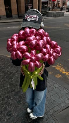 a person holding a bunch of balloons on the street