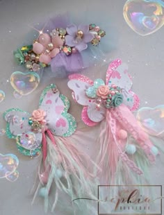 three hair clips with pastel colors and feathers