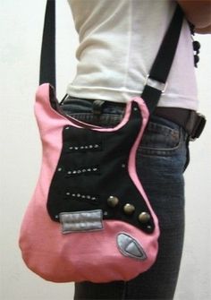 a woman holding a pink purse with studded details on the front and side pockets