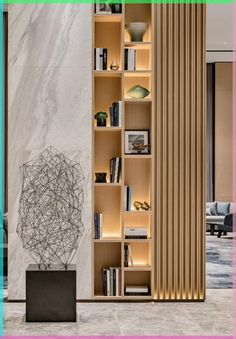 a book shelf filled with lots of books next to a wall mounted art piece in a living room