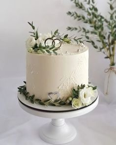 a wedding cake with white flowers and greenery