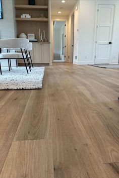 a living room with hard wood flooring and white furniture in the backround