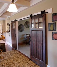 an open door leading to a kitchen and living room with pictures hanging on the wall