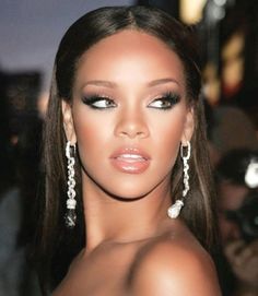 a close up of a person wearing large earrings and a dress with pearls on it