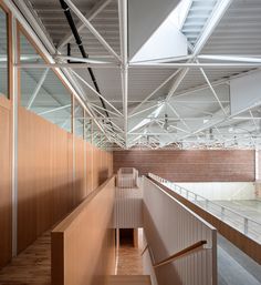 the inside of an empty building with wooden walls and metal railings on both sides