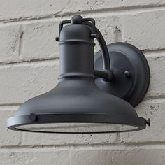 an outdoor light mounted on the side of a brick wall