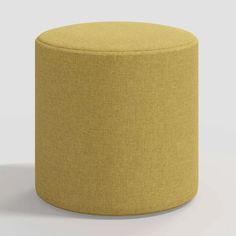 a yellow round ottoman sitting on top of a white floor