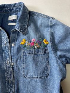 a denim shirt with flowers embroidered on it