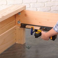 a man is working on a piece of wood with drillers and screwdrivers