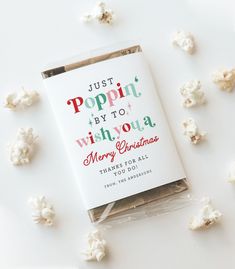 a bag of popcorn sitting on top of a white table next to small pieces of candy