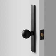 an open door with a black handle and knob on the outside wall, in front of a white wall