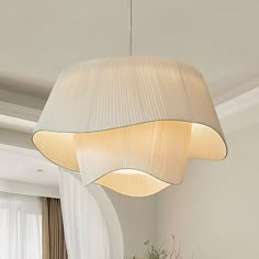 a white lamp hanging over a dining room table