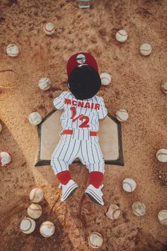 a paper cut out of a baseball player laying on the ground next to some balls